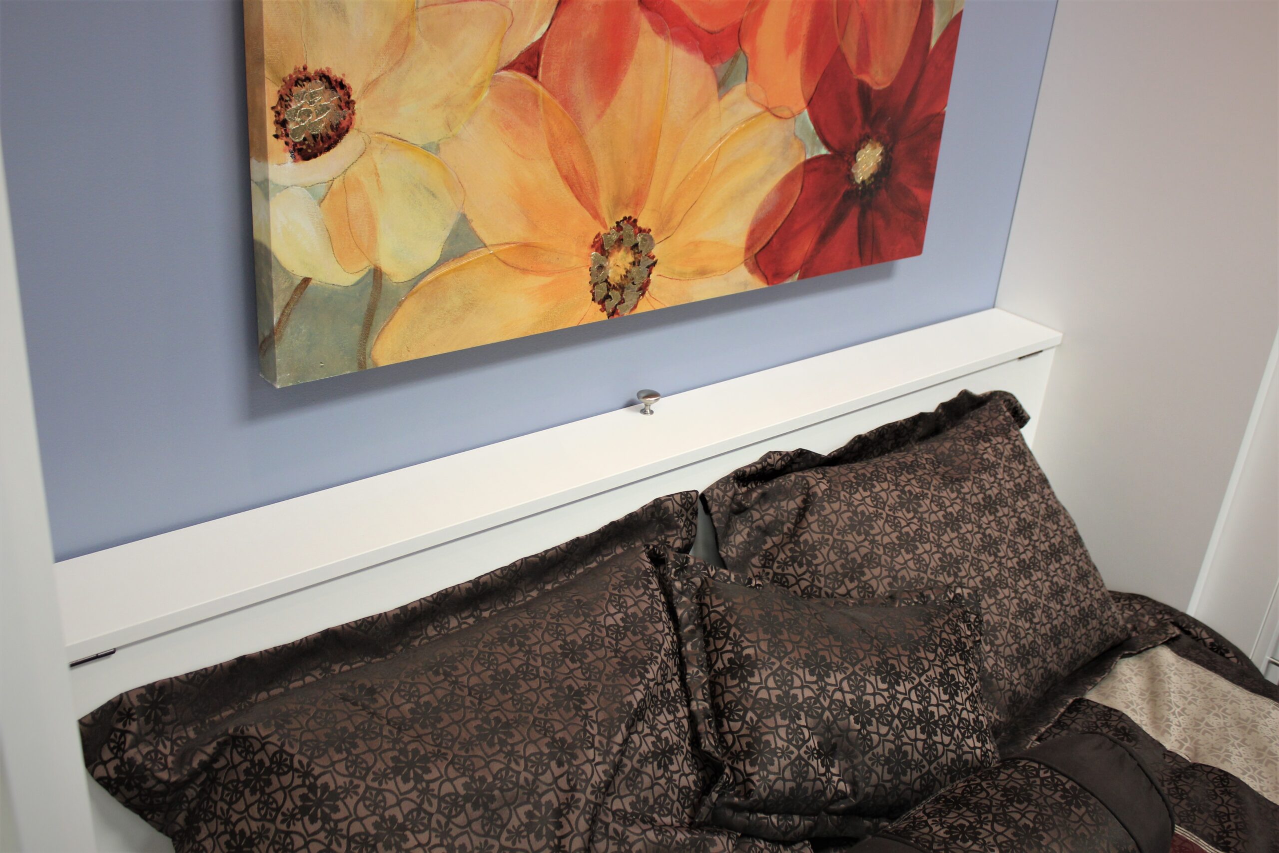 White Alpine Pillow Storage Headboard with Knob acting as the handle and the touch plate